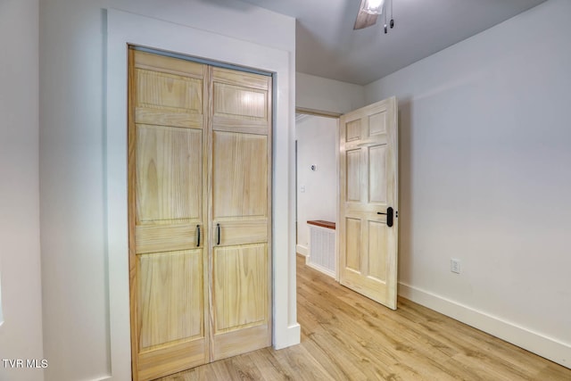 unfurnished bedroom featuring ceiling fan, a closet, and light hardwood / wood-style floors