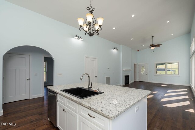 kitchen with ceiling fan with notable chandelier, dark hardwood / wood-style floors, a kitchen island with sink, and sink