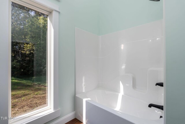 bathroom featuring a wealth of natural light and separate shower and tub