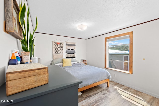 bedroom with a textured ceiling and light wood-type flooring