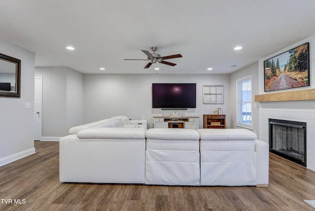 living room featuring wood-type flooring and ceiling fan