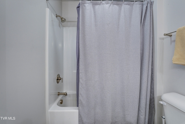 bathroom featuring toilet and shower / bath combination with curtain