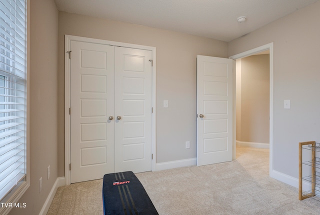 unfurnished bedroom featuring light carpet and a closet