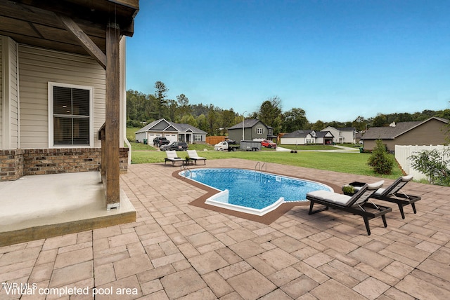 view of pool with a lawn and a patio area