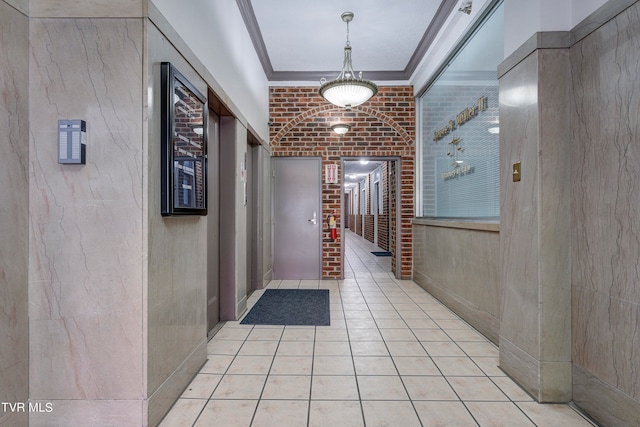 hall featuring brick wall and light tile patterned flooring