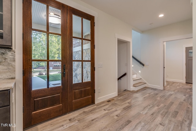 doorway to outside featuring light wood-type flooring, french doors, and a healthy amount of sunlight