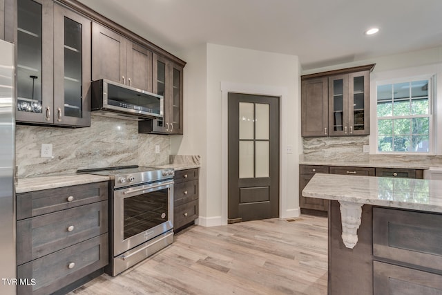 kitchen featuring light hardwood / wood-style flooring, stainless steel appliances, exhaust hood, and dark brown cabinetry