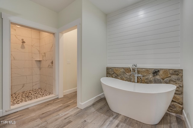 bathroom with independent shower and bath and hardwood / wood-style flooring