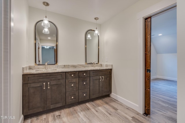 bathroom featuring vaulted ceiling, hardwood / wood-style flooring, and vanity