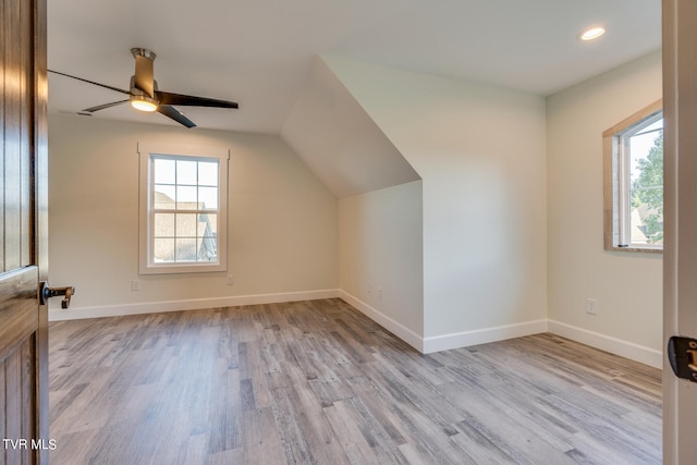 additional living space with lofted ceiling, light hardwood / wood-style flooring, and ceiling fan