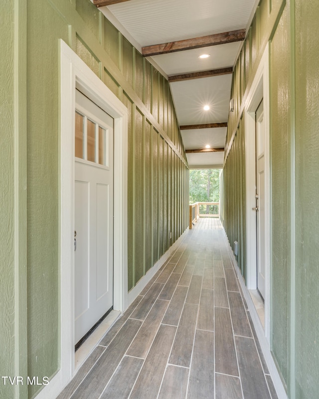 hallway with hardwood / wood-style flooring and beam ceiling