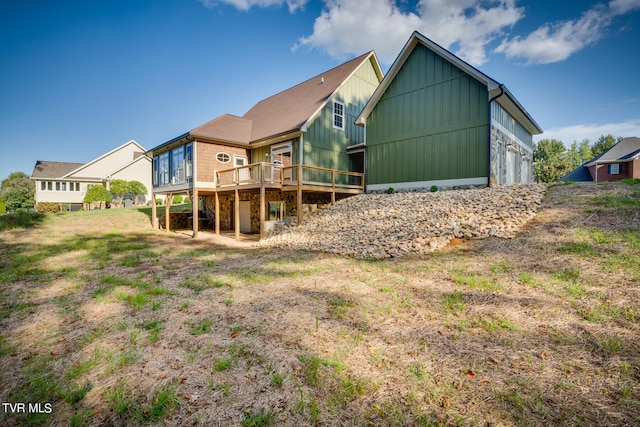 back of property featuring a garage and a deck