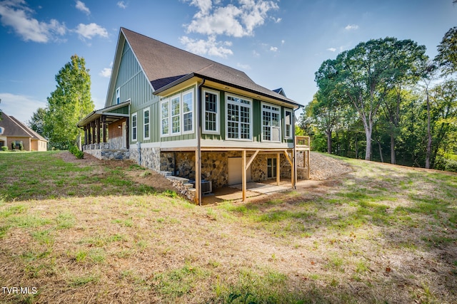 back of property with a lawn and a patio