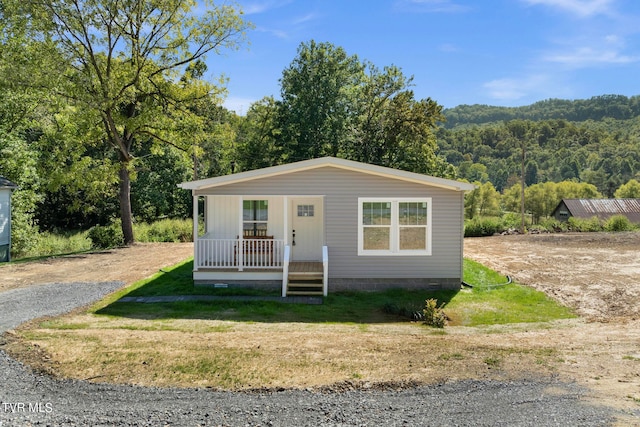 view of front of house featuring covered porch and a front lawn