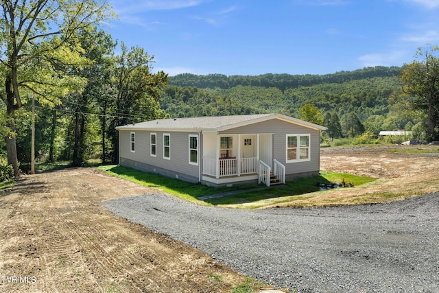 manufactured / mobile home featuring a porch and a front yard