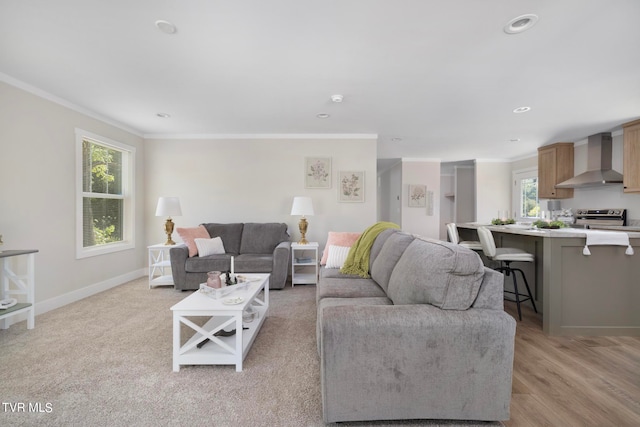 living room featuring a wealth of natural light, crown molding, and light hardwood / wood-style floors