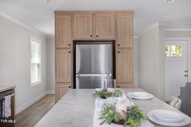 interior space featuring light brown cabinetry, appliances with stainless steel finishes, light hardwood / wood-style floors, ornamental molding, and light stone counters