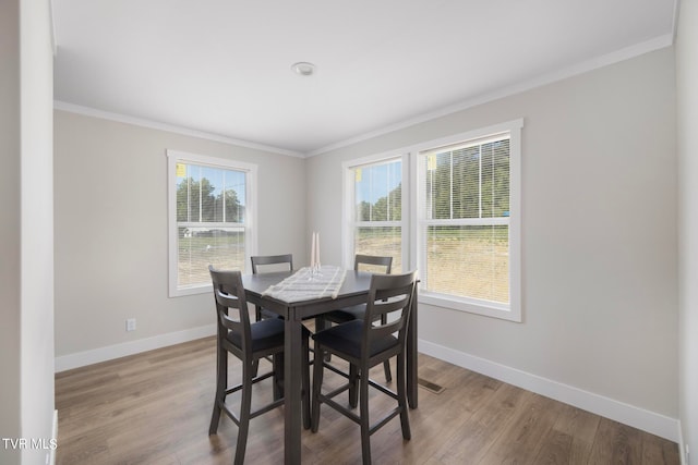 dining area featuring crown molding and hardwood / wood-style flooring