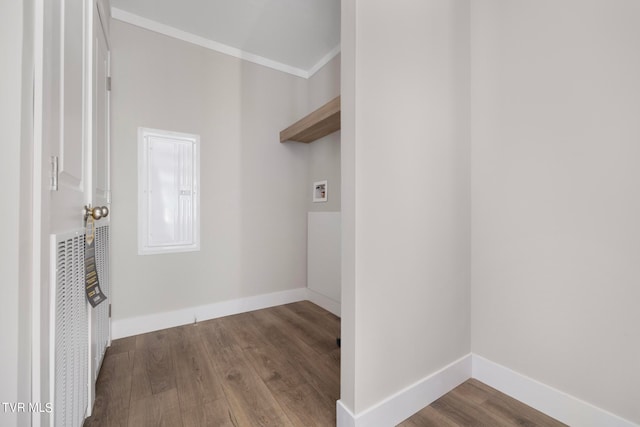 washroom with ornamental molding, hookup for a washing machine, and wood-type flooring