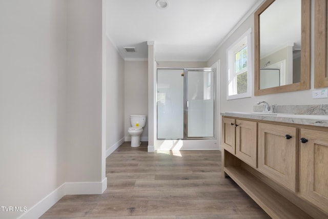 bathroom with an enclosed shower, hardwood / wood-style flooring, toilet, vanity, and ornamental molding