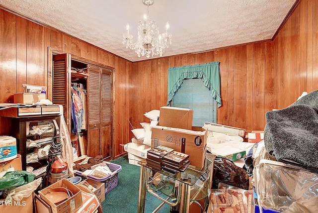 misc room featuring carpet flooring, a textured ceiling, wooden walls, and a chandelier