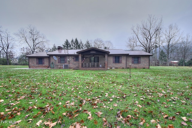 ranch-style house featuring central air condition unit and a front lawn