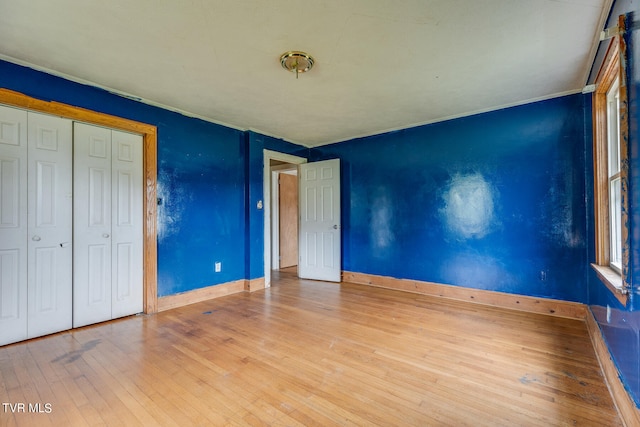 unfurnished bedroom with a closet and hardwood / wood-style floors