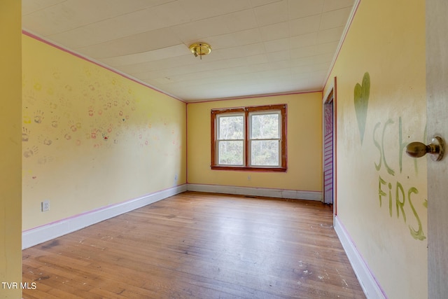 spare room with light wood-type flooring and ornamental molding