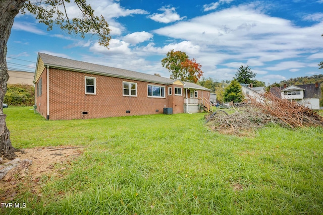 back of property with cooling unit and a lawn