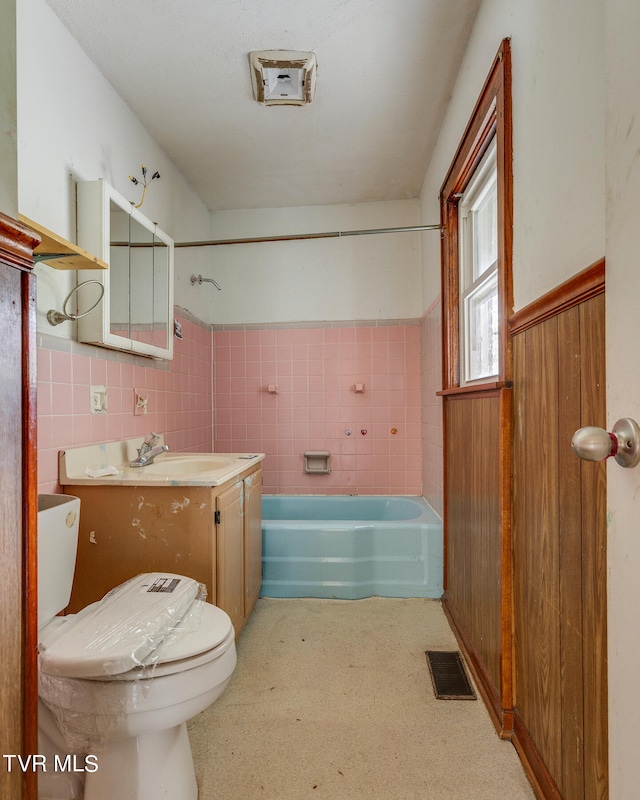 full bathroom featuring tile walls, shower / washtub combination, vanity, and toilet