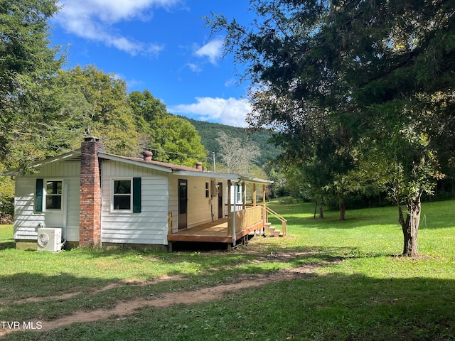 back of property featuring a yard, ac unit, and a deck