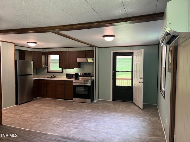 kitchen featuring appliances with stainless steel finishes, beam ceiling, wooden walls, and dark brown cabinetry