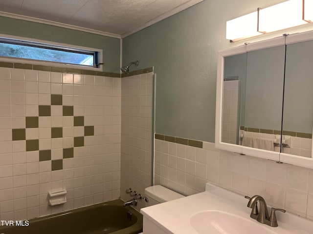 full bathroom featuring vanity, tile walls, toilet, tiled shower / bath, and decorative backsplash