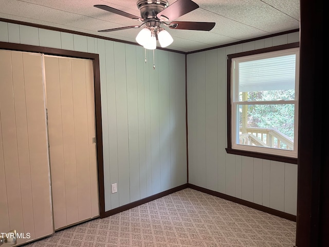 unfurnished room with light colored carpet and ceiling fan