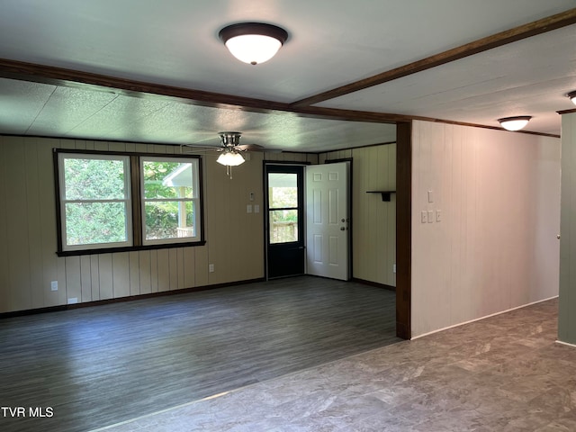 unfurnished room with ceiling fan, wood walls, and hardwood / wood-style flooring