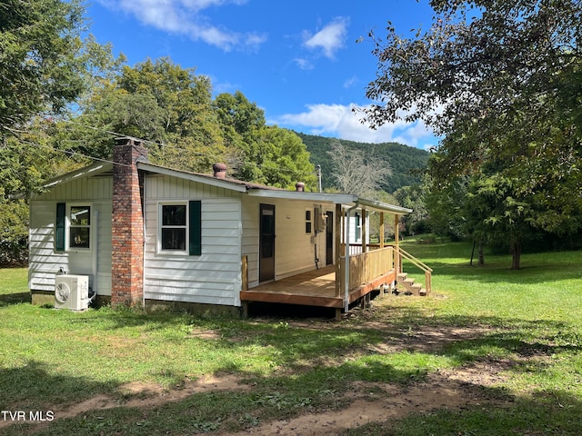 back of house featuring ac unit, a yard, and a wooden deck