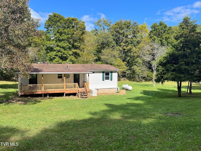 rear view of property with a lawn and a wooden deck