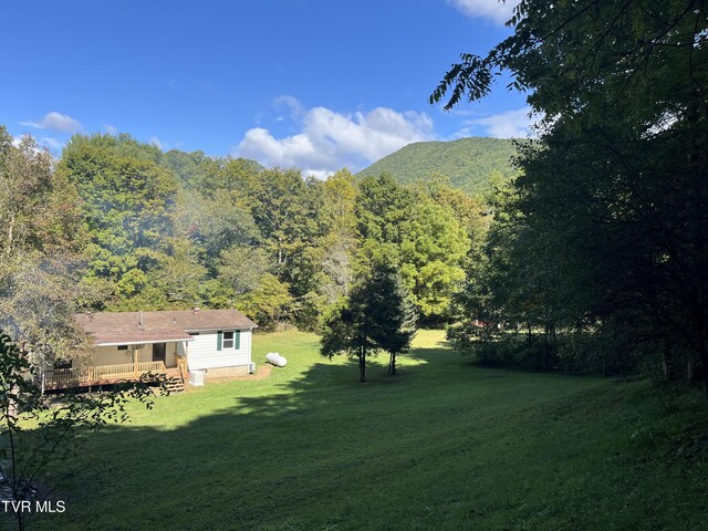 view of yard with a deck with mountain view