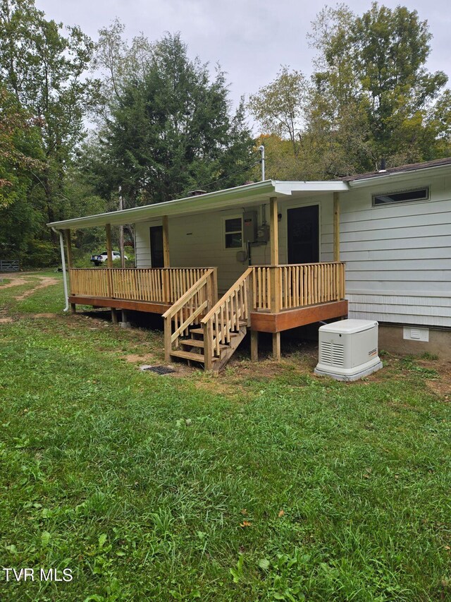 back of house with a wooden deck and a lawn