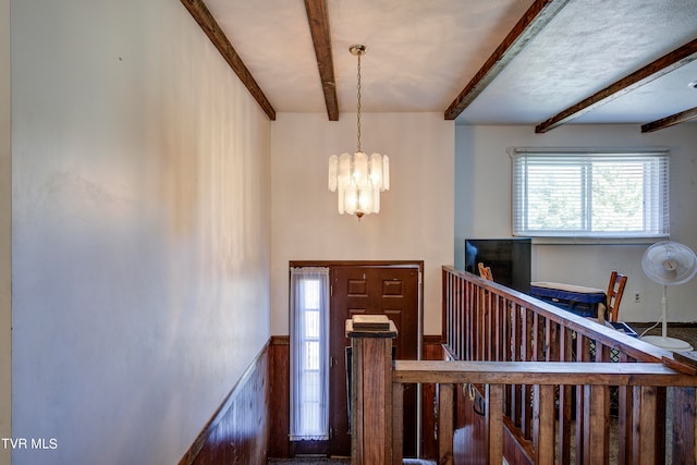 foyer featuring beamed ceiling and a chandelier