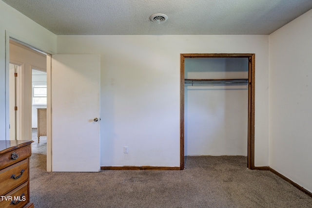 unfurnished bedroom featuring carpet floors, a textured ceiling, and a closet