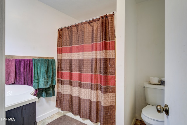 bathroom with a shower with curtain, vanity, toilet, and tile patterned floors