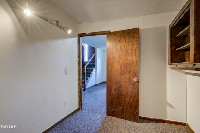 unfurnished room with a textured ceiling and carpet flooring