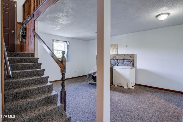 staircase with a textured ceiling and carpet