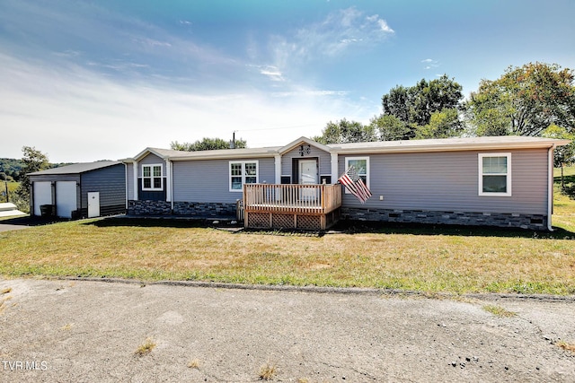 manufactured / mobile home featuring a front lawn, an outdoor structure, a deck, and a garage