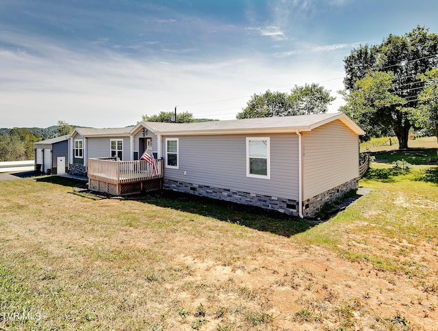 rear view of property with a wooden deck and a yard