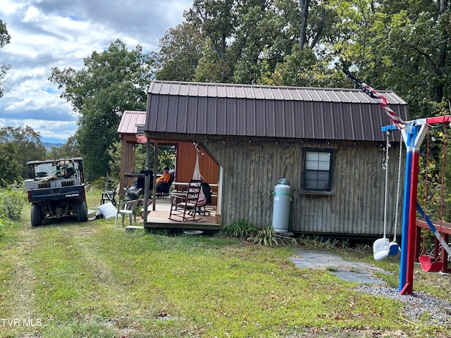 view of outbuilding with a playground and a yard