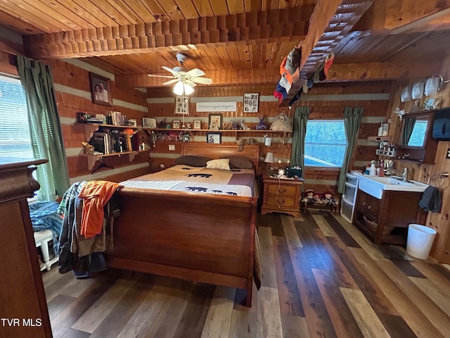 bedroom with beamed ceiling, wooden walls, dark hardwood / wood-style floors, and wood ceiling