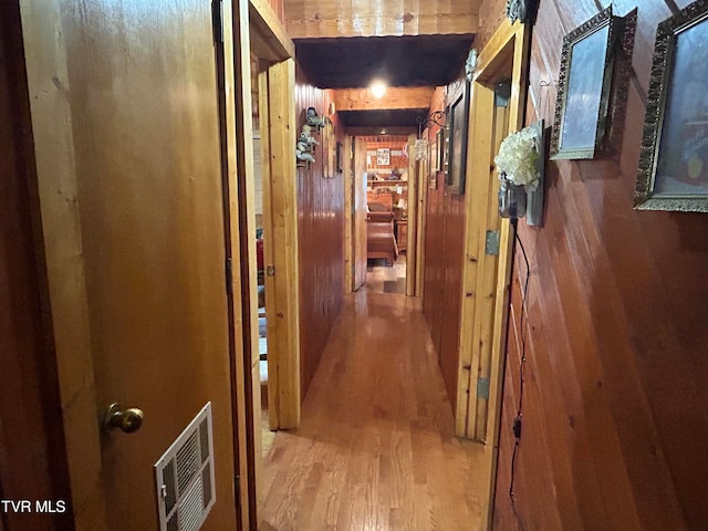 corridor featuring wood walls and wood-type flooring