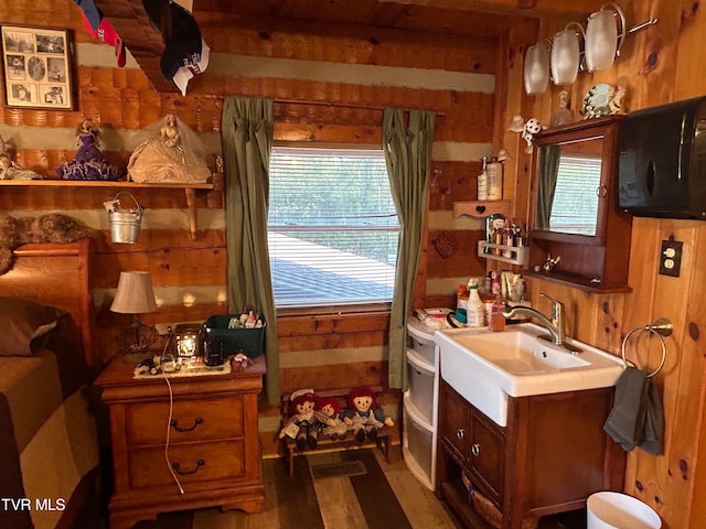 kitchen with dark hardwood / wood-style floors, wooden walls, and sink